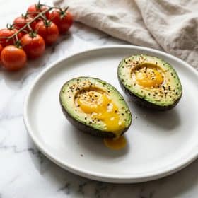 Baked avocado egg boats with everything seasoning on white plate