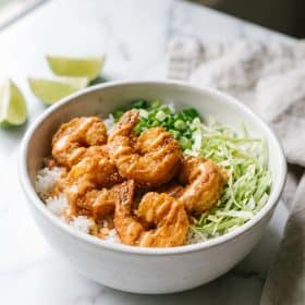 Bang bang shrimp bowl with crispy shrimp over rice on white plate