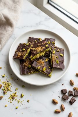 Dubai chocolate bark with pistachio filling and crispy pastry on white plate