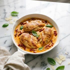 Marry me chicken in creamy sun-dried tomato sauce in white skillet