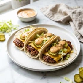 Smash burger tacos with crispy beef in flour tortillas on white plate