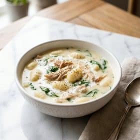 Creamy chicken gnocchi soup in a white bowl on marble