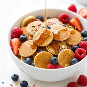 Close up of pancake cereal with maple syrup and colorful toppings