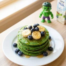 Green Hulk spinach banana pancakes stacked with berries