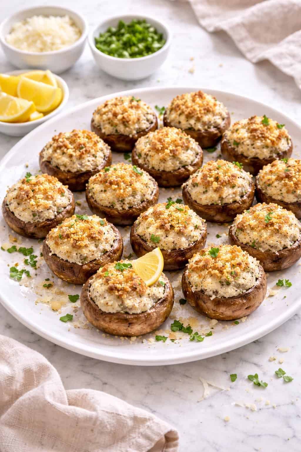 Stuffed mushrooms in a white ceramic baking dish on marble